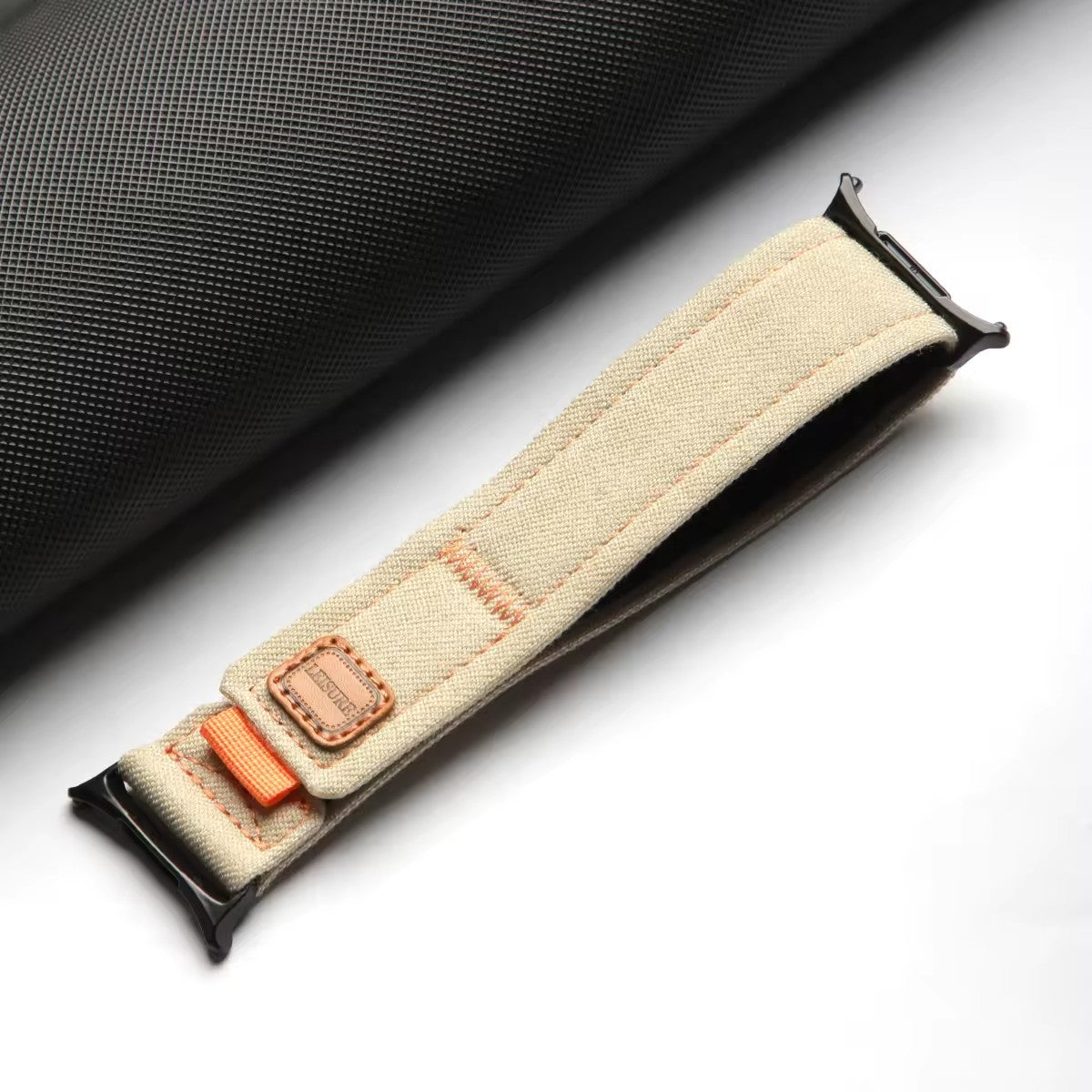 Correa de lona beige para Galaxy Watch Ultra de The Strap Society México con detalles en naranja y herrajes negros